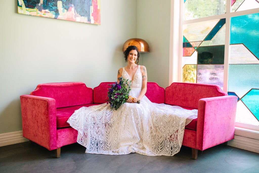 bride in white sitting on pink couch at The Fig House Wedding