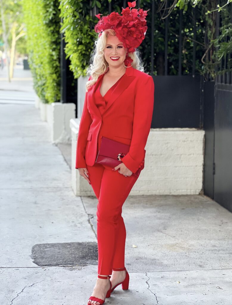 blonde woman standing in bright red pants suit with red heels. holly gray events los angeles wedding planner. wedding suit ideas
