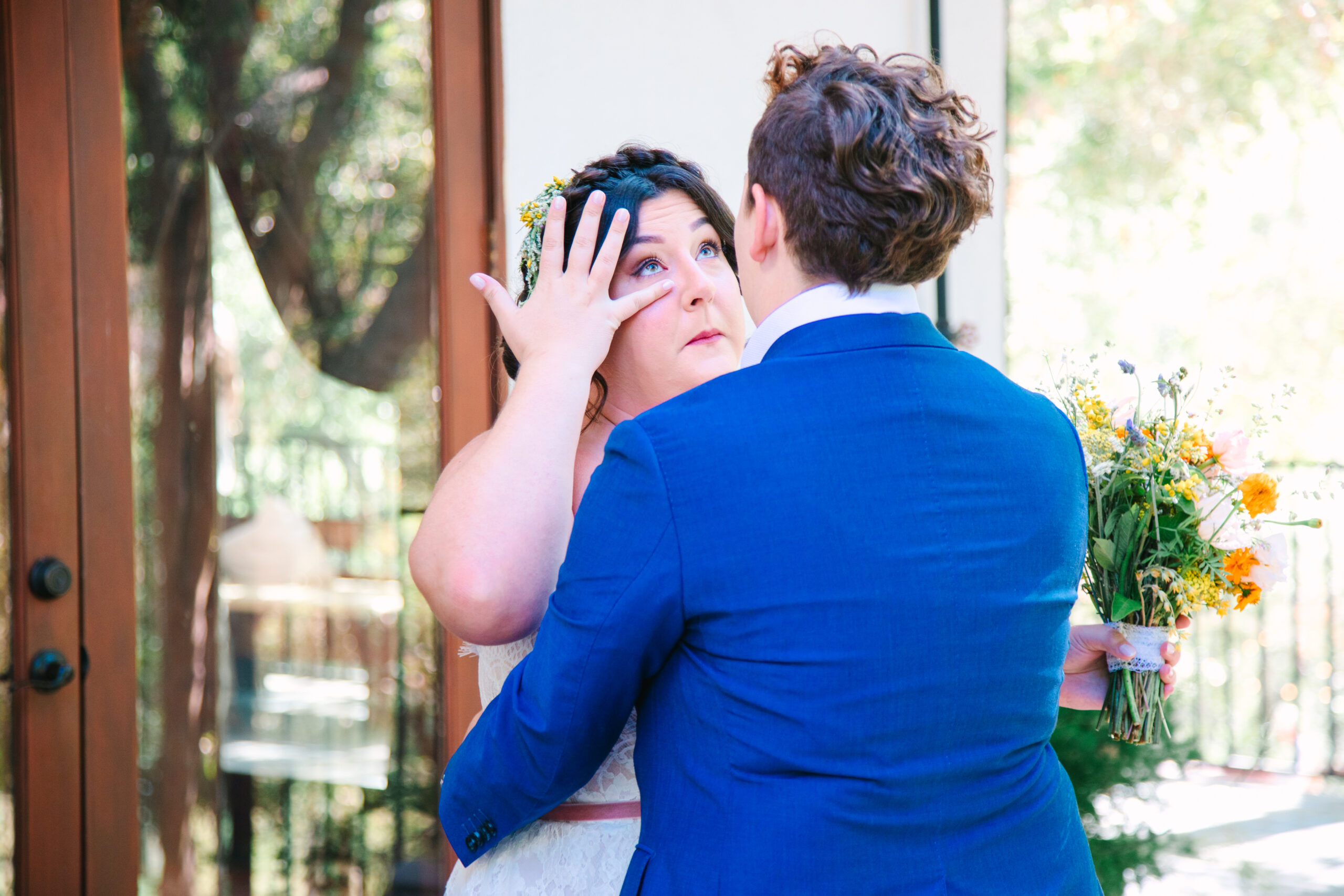 2 brides in white wedding dress and a blue suit during their first look. los angeles wedding photographer, lgbtq wedding photographer, gay wedding photographer