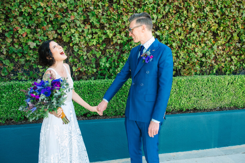 bride and groom, first look, groom in blue suit and bride in white sleeveless lace gown in front of The Fig House in los angeles
