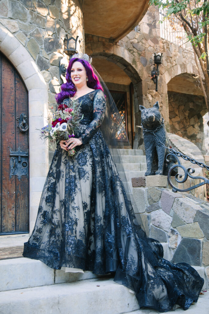 bride with purple hair standing in long black lace wedding dress