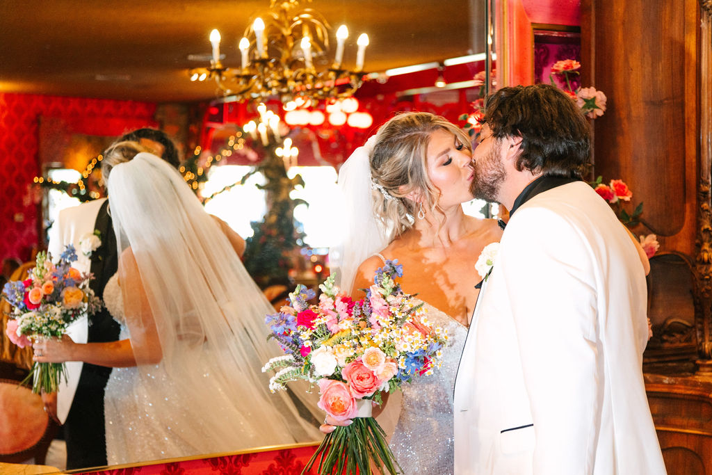 Madonna Inn Wedding, bride and groom in front of a mirror kissing