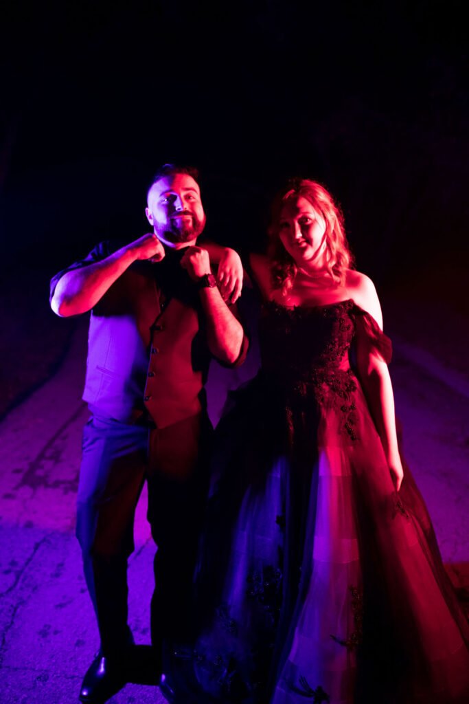 Topanga Wedding Photographer, bride and groom standing in the dark bathed in neon purple and red light.