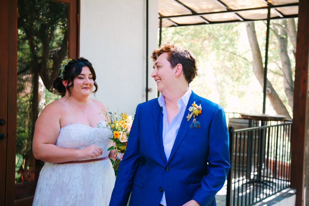 1909 Wedding venue, bride in a blue suit and bride in a white dress, first look