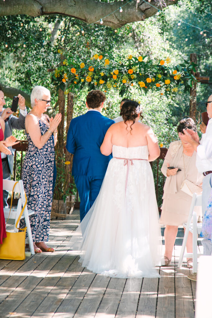 Lesbian Wedding Ceremony, one bride in a blue suit, one bride in a white dress, 1909 Wedding Venue 