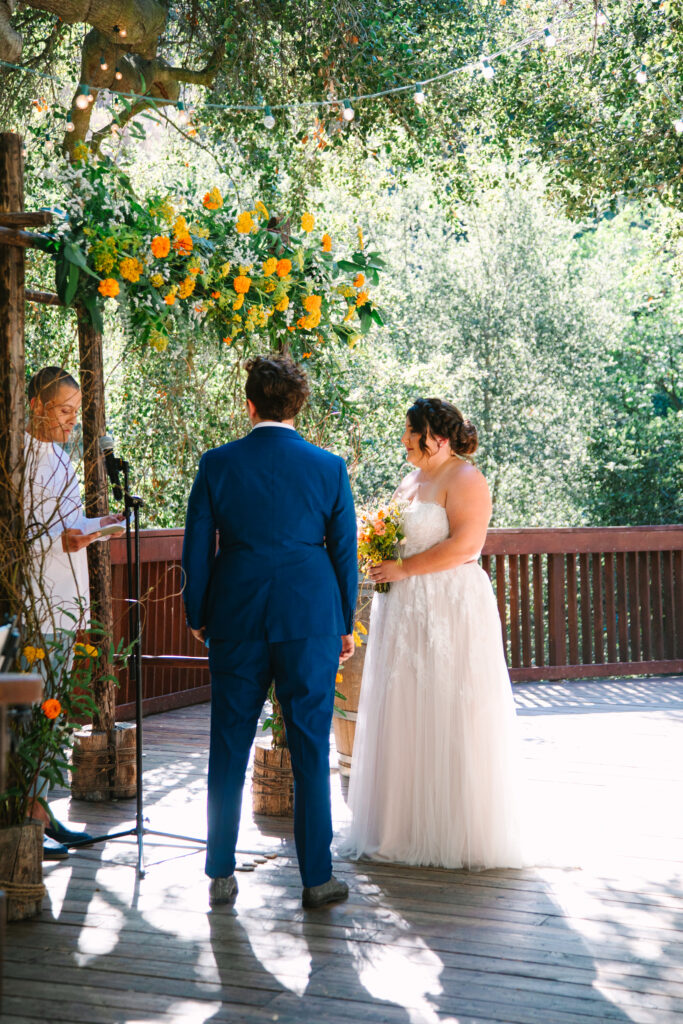 Lesbian Wedding Ceremony, one bride in a blue suit, one bride in a white dress, 1909 Wedding Venue 
