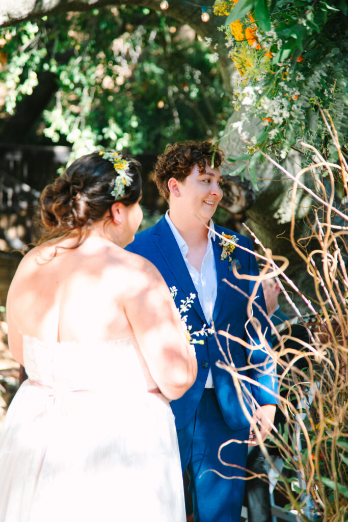 Lesbian Wedding Ceremony, one bride in a blue suit, one bride in a white dress, 1909 Wedding Venue 