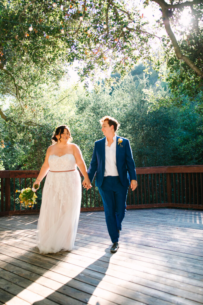 1909 Wedding venue topanga, bride in a blue suit and bride in a white dress walking together