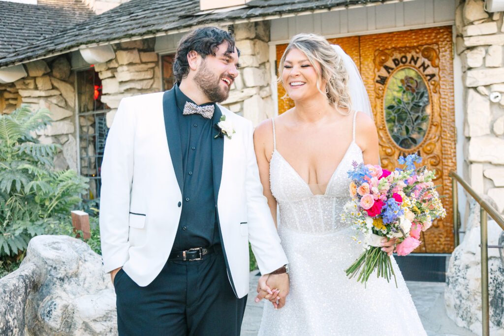 Madonna Inn Wedding Bride and Groom Portraits outside by the wooden and stained-glass doors.