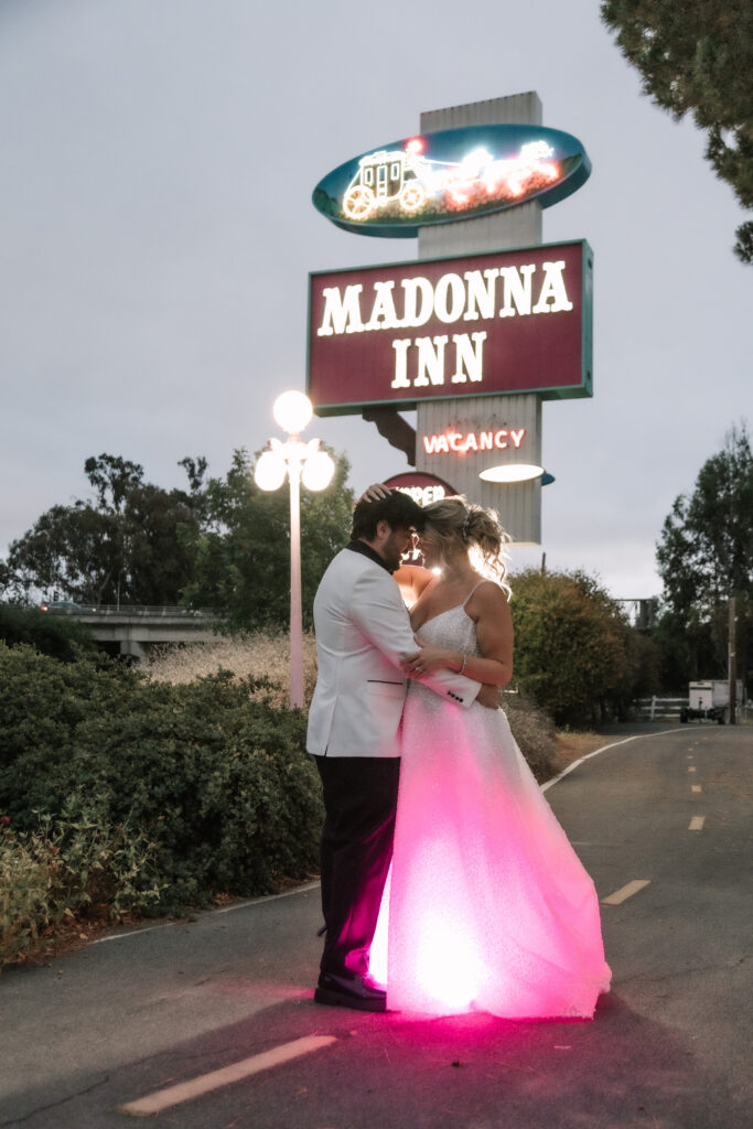 Madonna Inn Wedding Photographer Portraits with Bride and Groom by the neon sign.